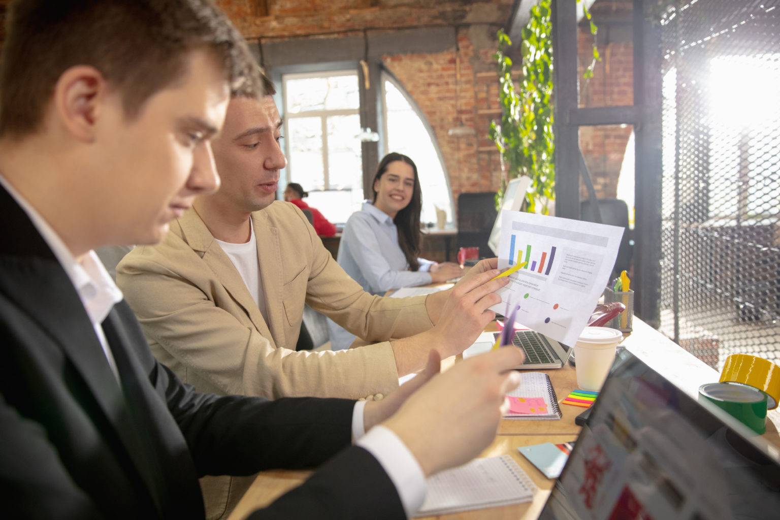 colleagues working together office using modern devices during creative meeting stationery laptop documents concept business office finance open space scaled
