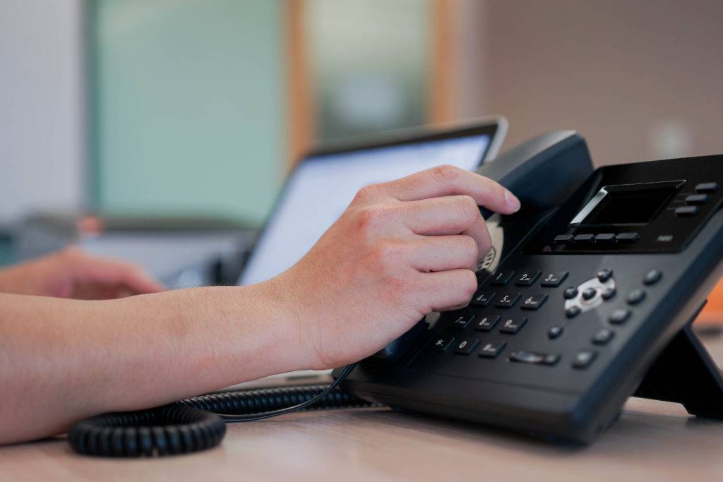 man hand touching handset telephone calling scaled