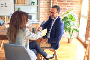 ghost calling what is Two middle age business workers smiling happy and confident. Working together with smile on face shaking hands at the office